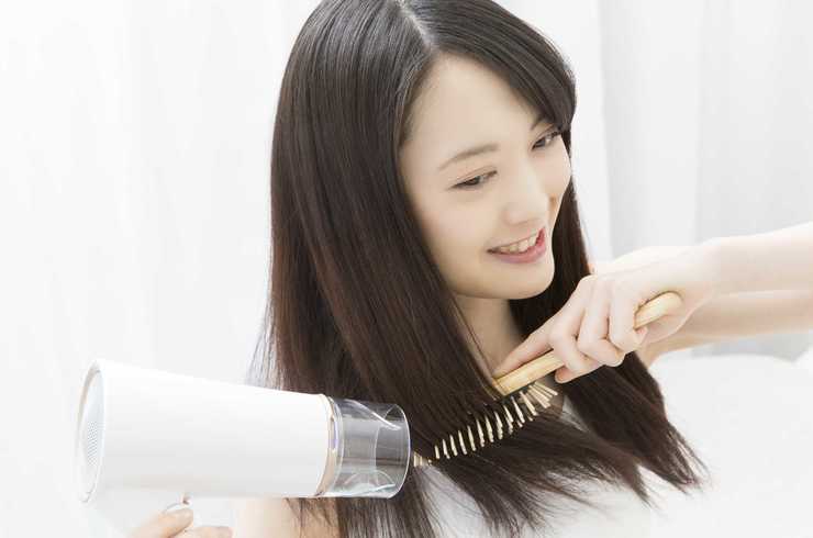 髪をブローする女性